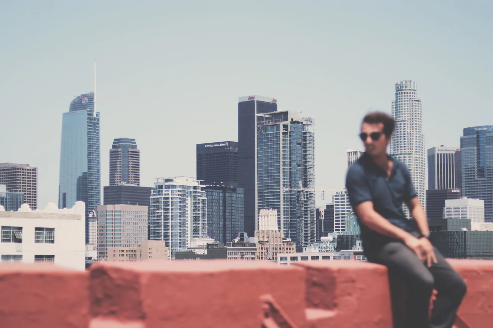 A creatively blurred portrait of a man with Los Angeles city skyline in the backdrop, showcasing urban life.