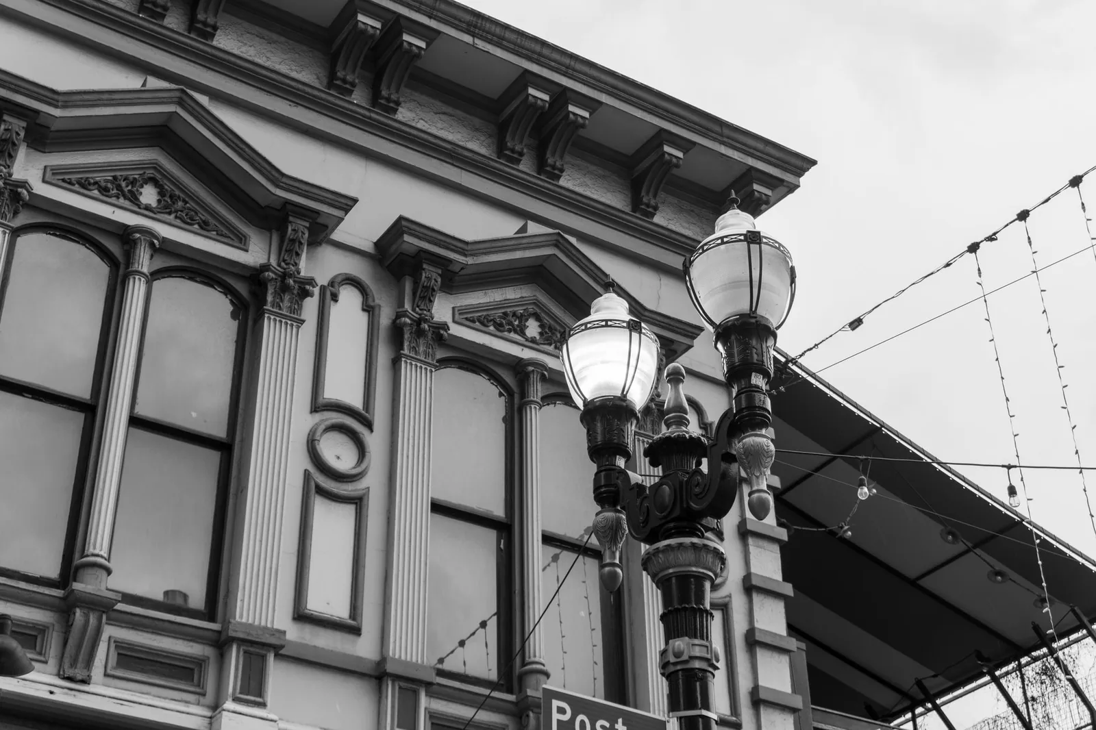 Black and white photo of detailed urban building and street lamps with classic design.